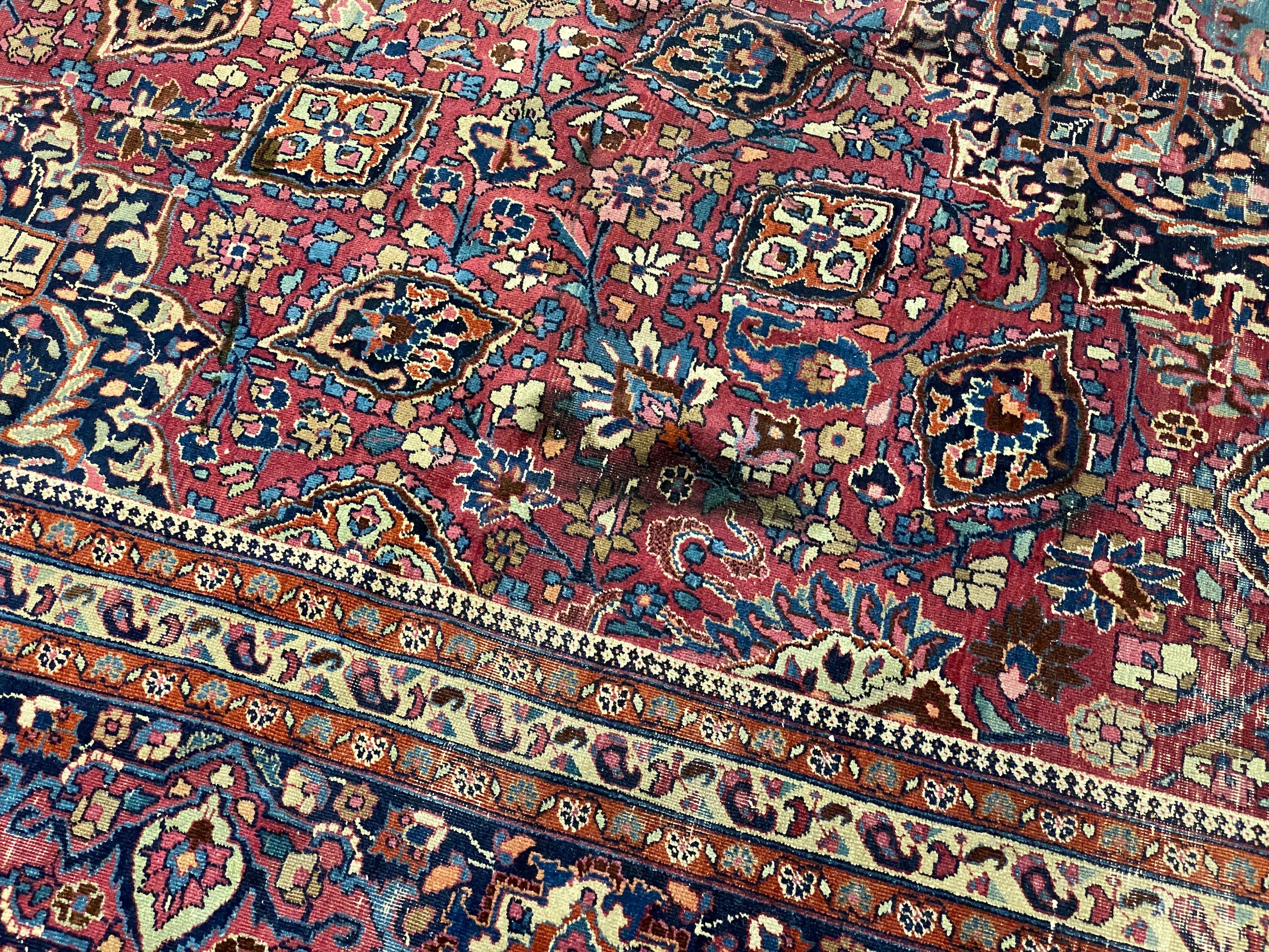 An early 20th century Heriz burgundy ground carpet, 412 x 305cm